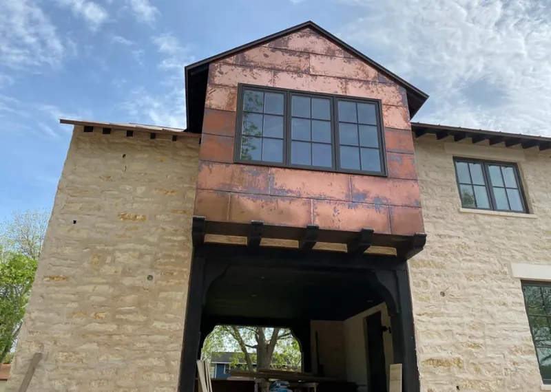 Copper metal panel facade on a stone building for Metal Roof Coating in Texas