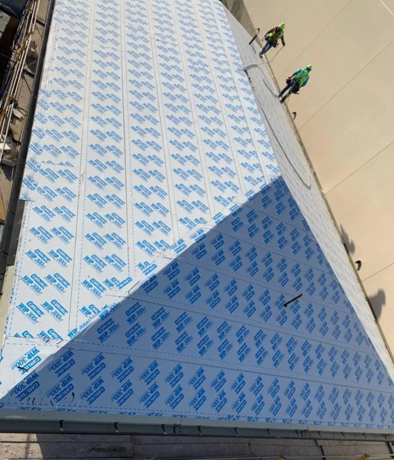 Professional roofers installing underlayment on a metal roof in Texas